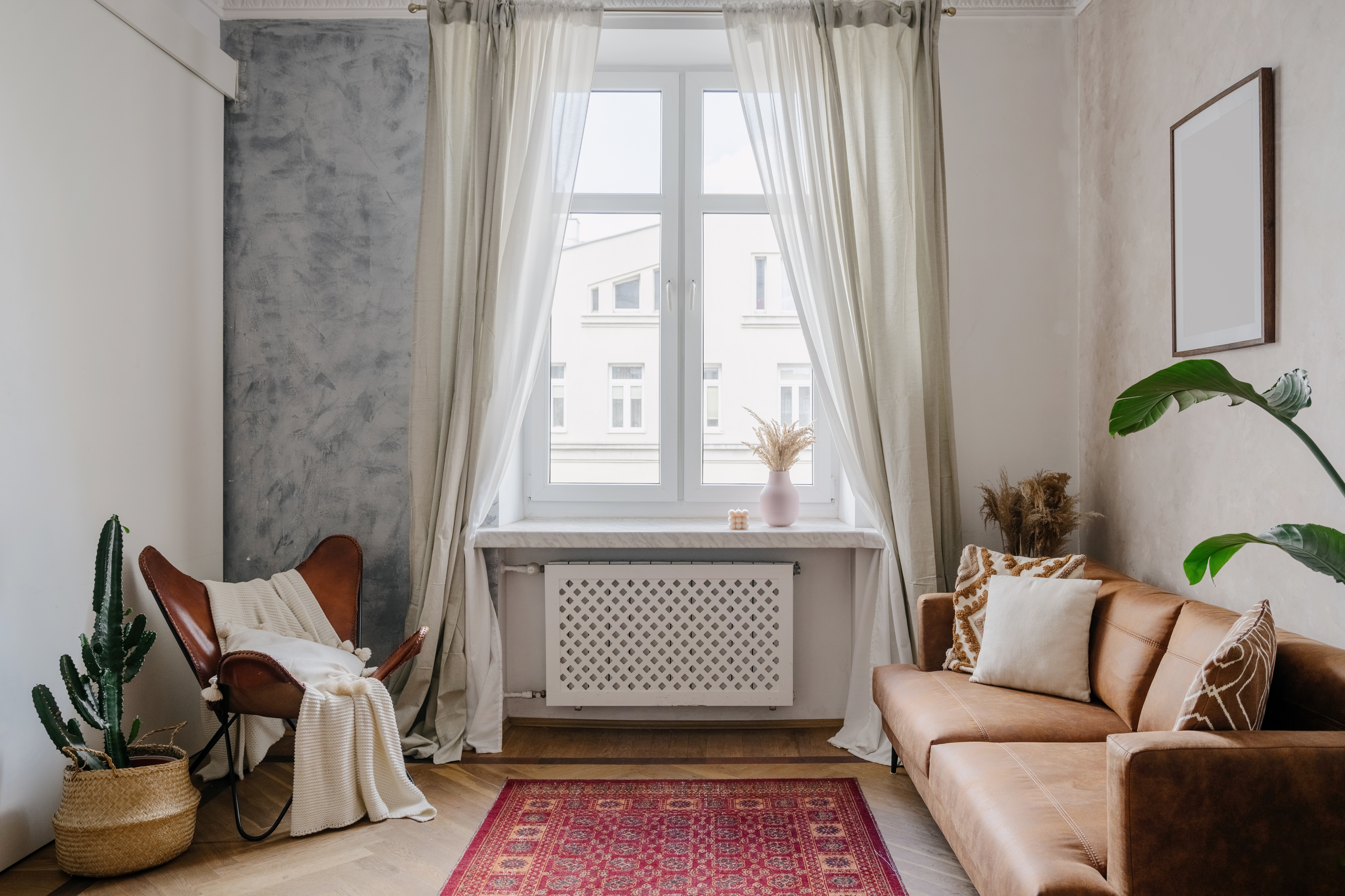 Cozy living room featuring a brown leather sofa, a butterfly chair