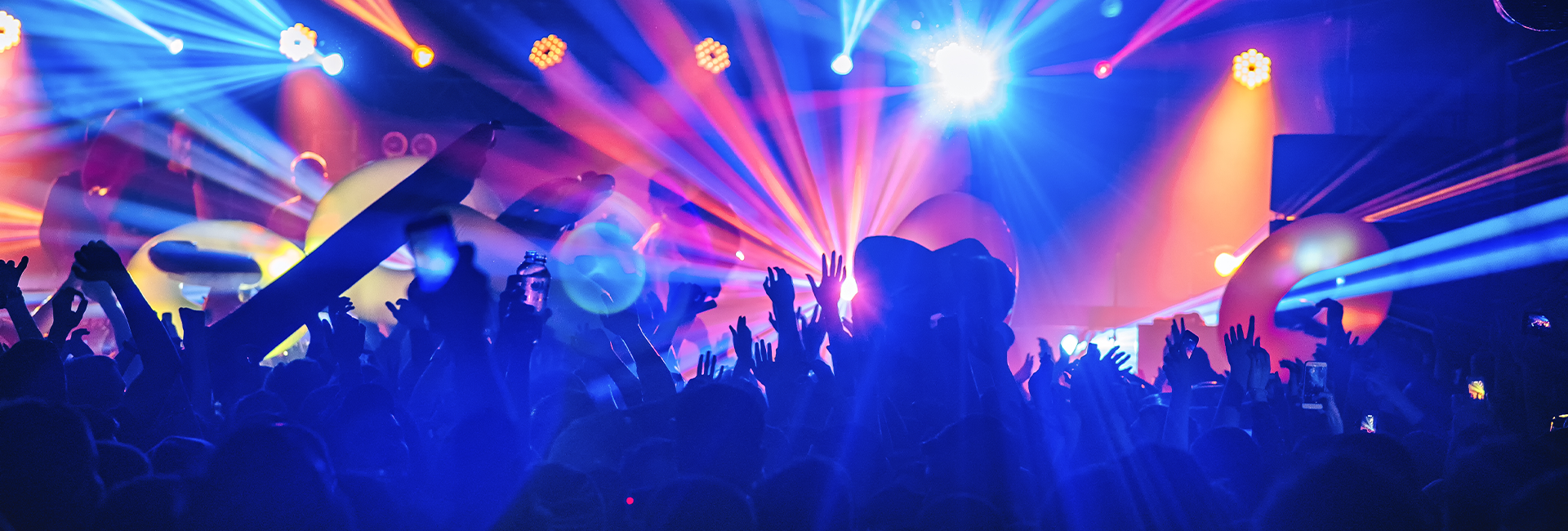 Vibrant concert scene with colorful lights illuminating a crowd