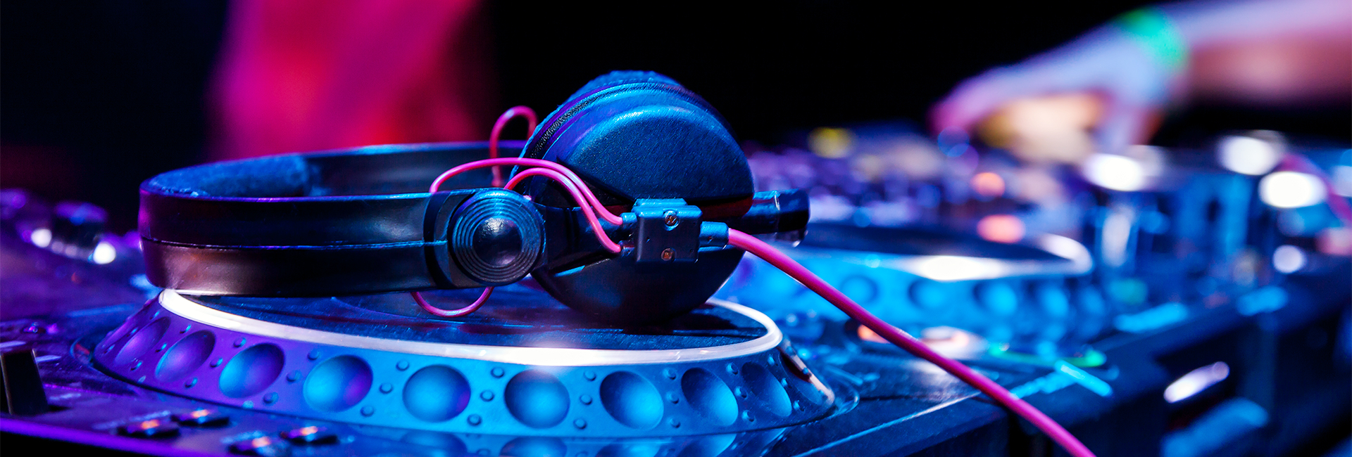 A pair of black headphones rests on a DJ turntable