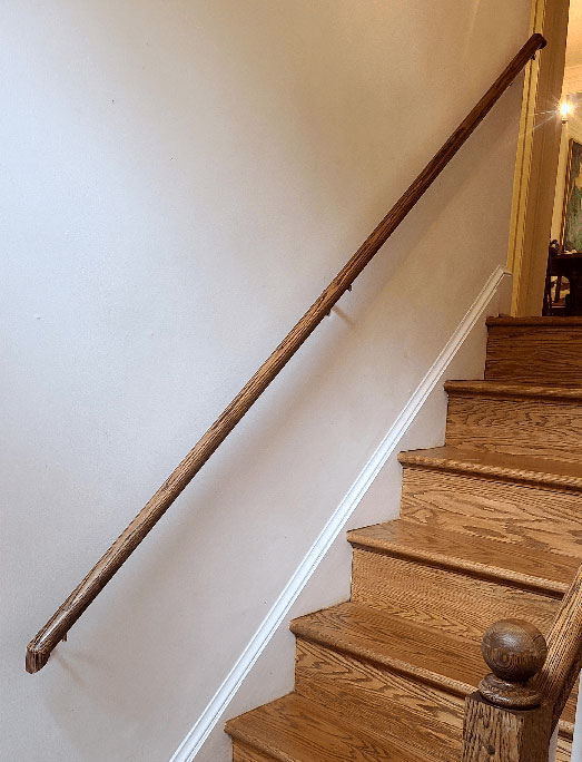 This image is a round wood railing handrail installed in Silverspring, MD and matches existing bannister wood railing on the opposite side.