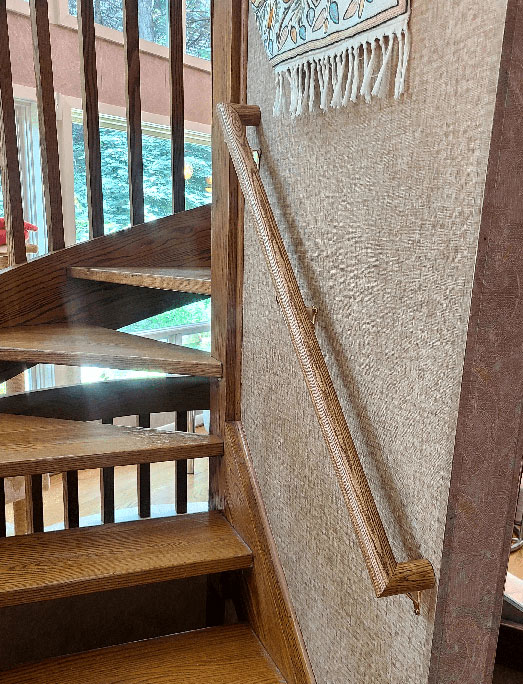 This is an image of Round Wood railing with returns, installed in a home in Olney, MD. It is stained and polyed to match existing decor.