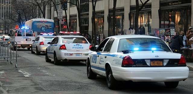 Several NYPD police cars with emergency lights on, on a New York City Street