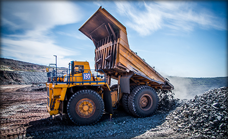 Yellow truck unloading stones