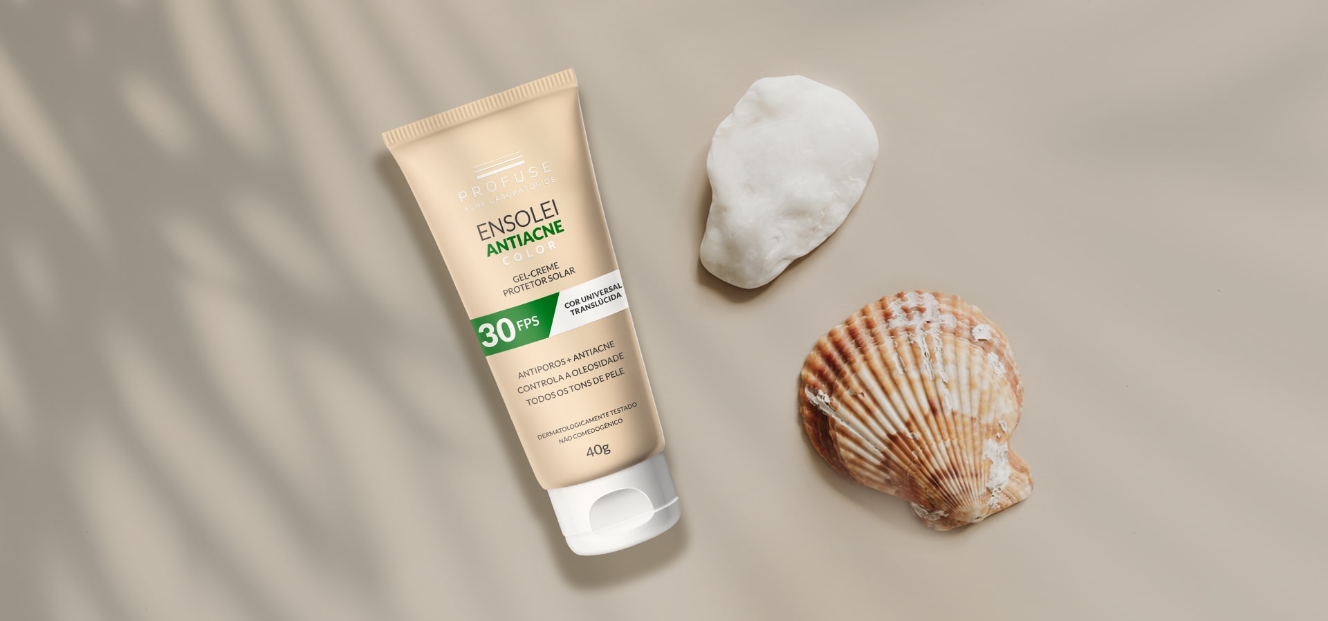 Ensolei Antiacne Color na areia com conchas ao lado