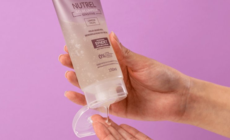 Modelo apertando o frasco de Nutrel Gel de Limpeza Sensitive