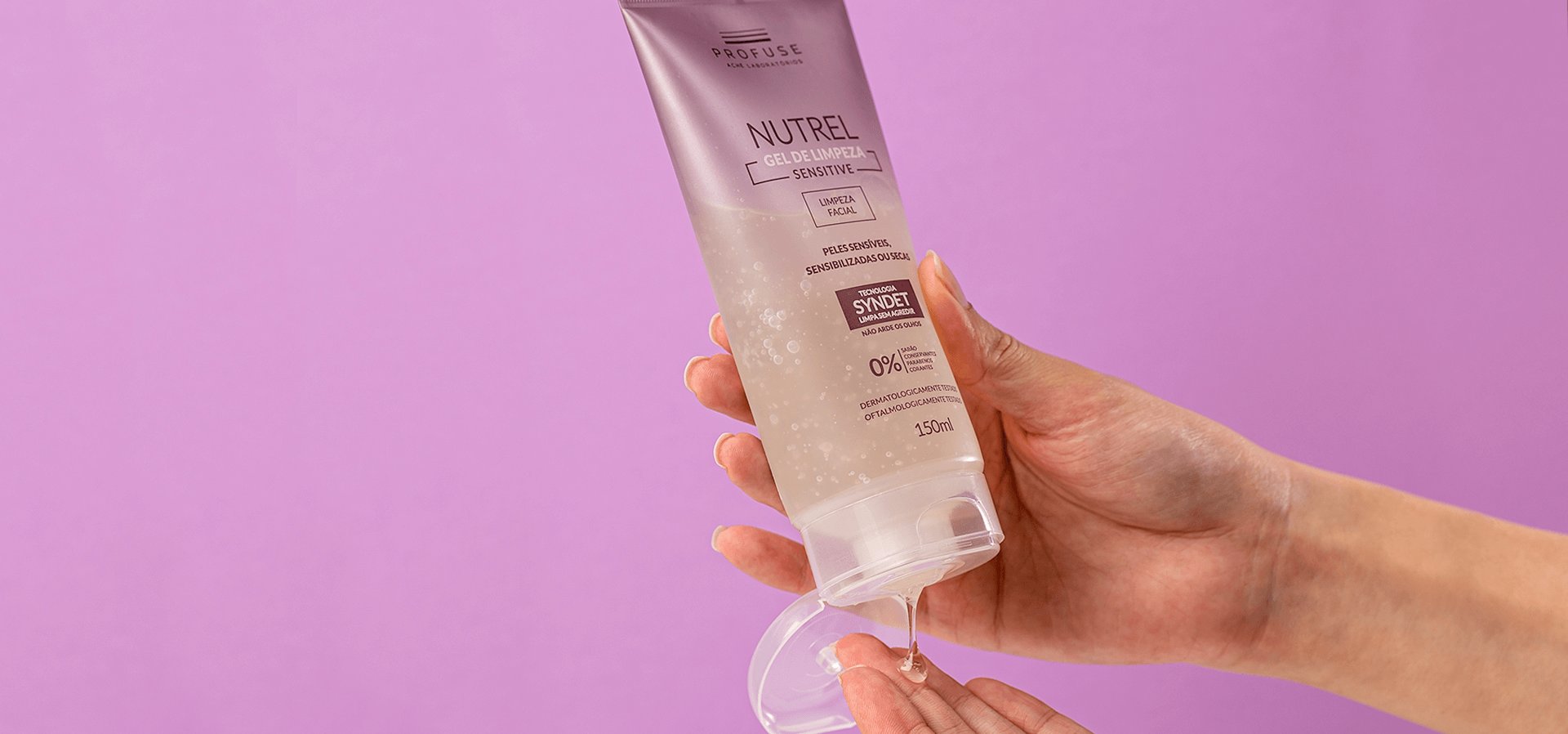 Imagem mostra uma pessoa a plicando o produto Nutrel Gel de Limpeza Sensitive em sua mão, em um fundo roxo