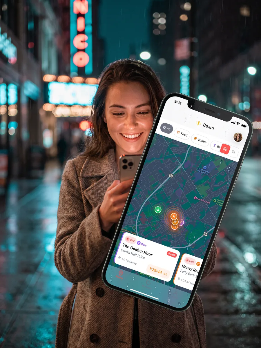A woman on the night street holds up her phone showing the Beam live map: coral rings pulsing around the pins and The Golden Hour, Drinks Half Price, 1:29:44 left