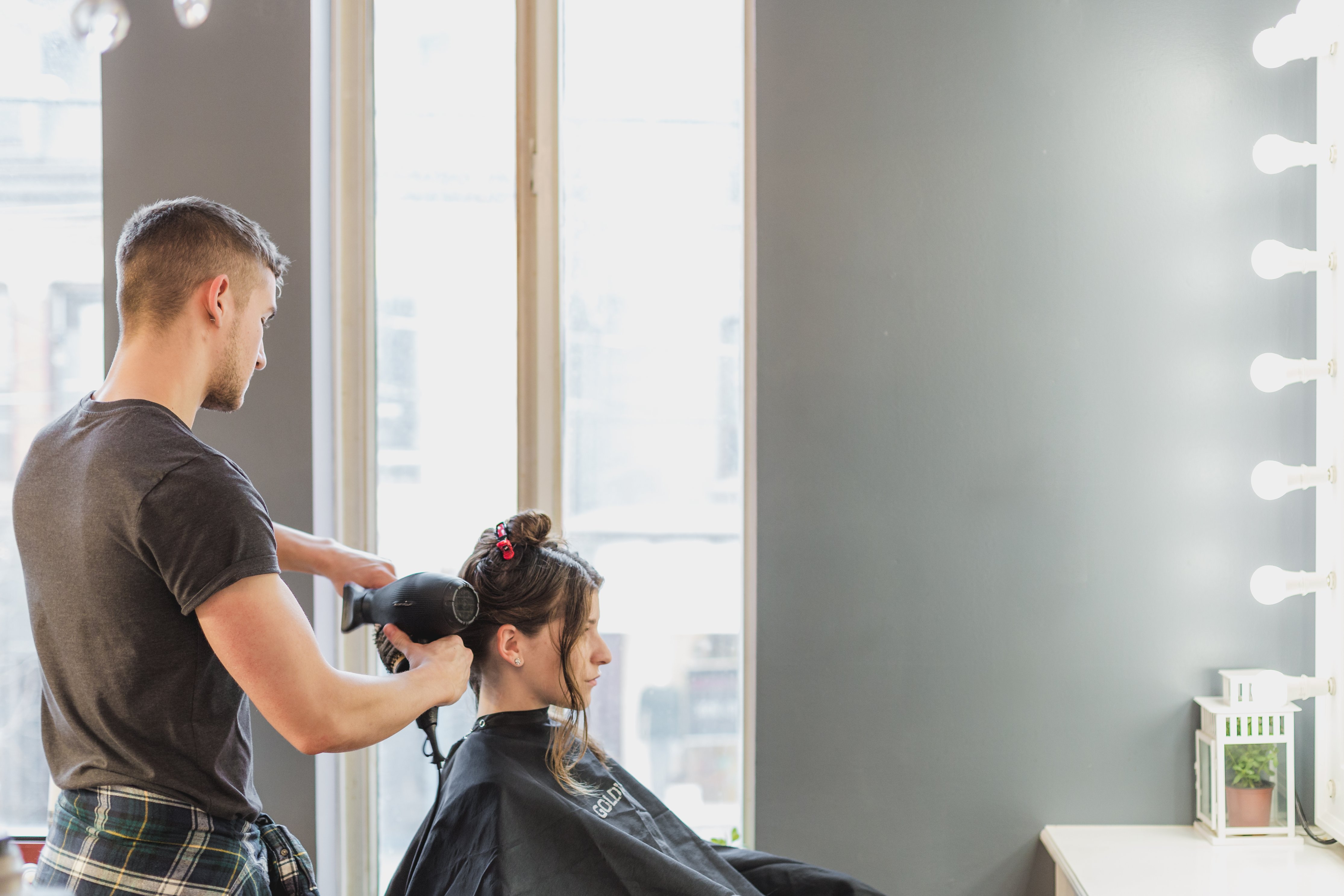 male cutting a woman's hair at hair salon