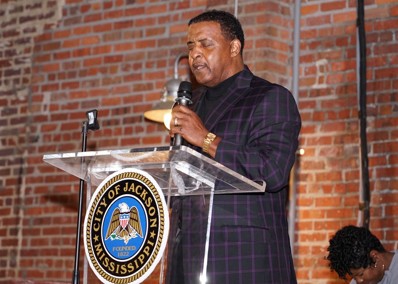 Reverend Praying At Podium