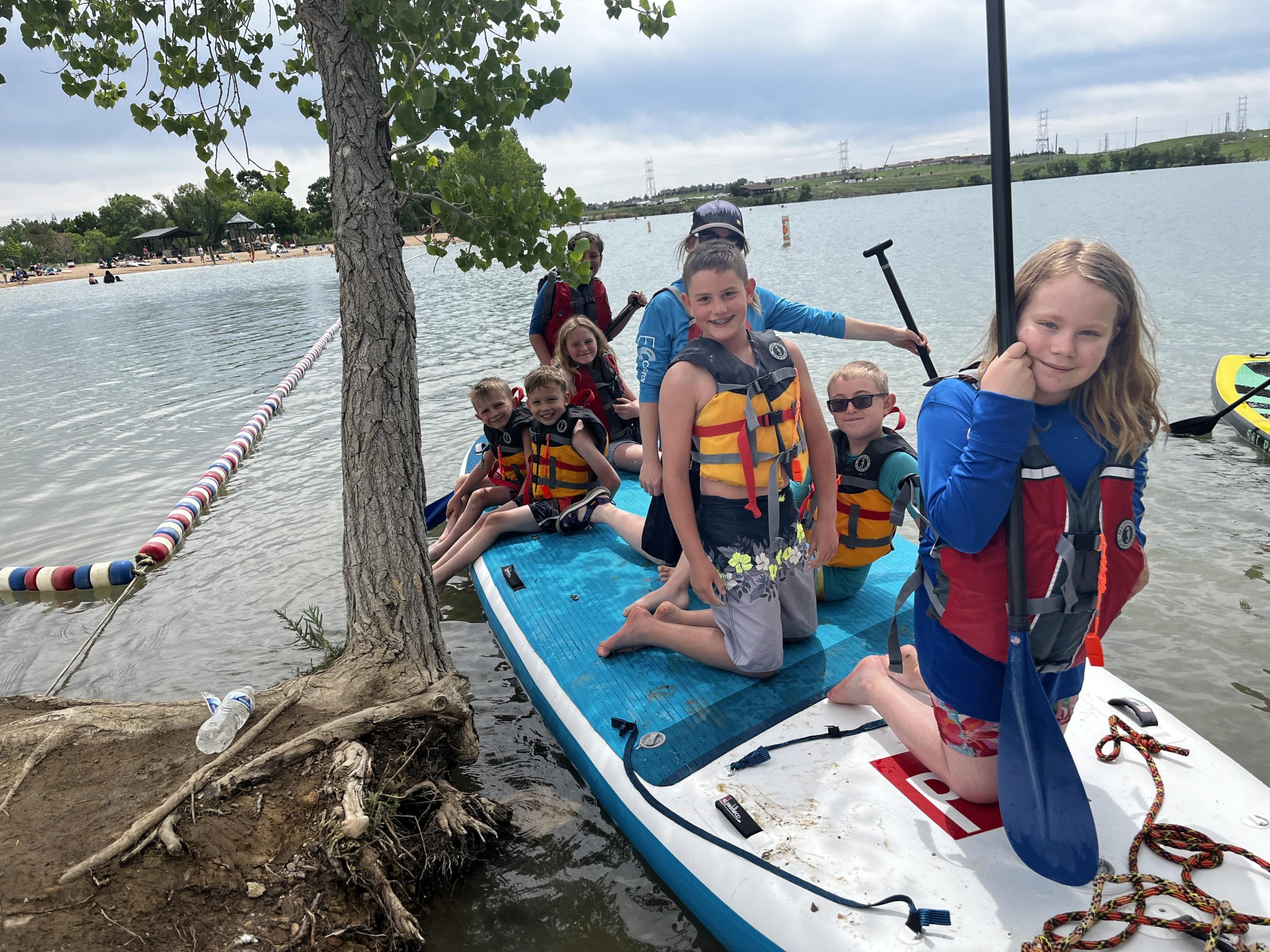 kids on a paddleboard at a lake