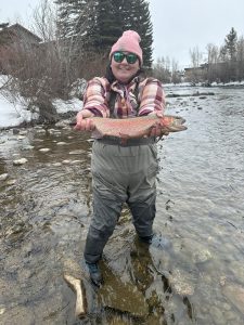 woman holding fish in the river