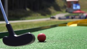 Mini Golf putter and ball on a course