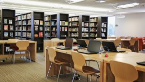 tables and laptops for studying with bookshelves