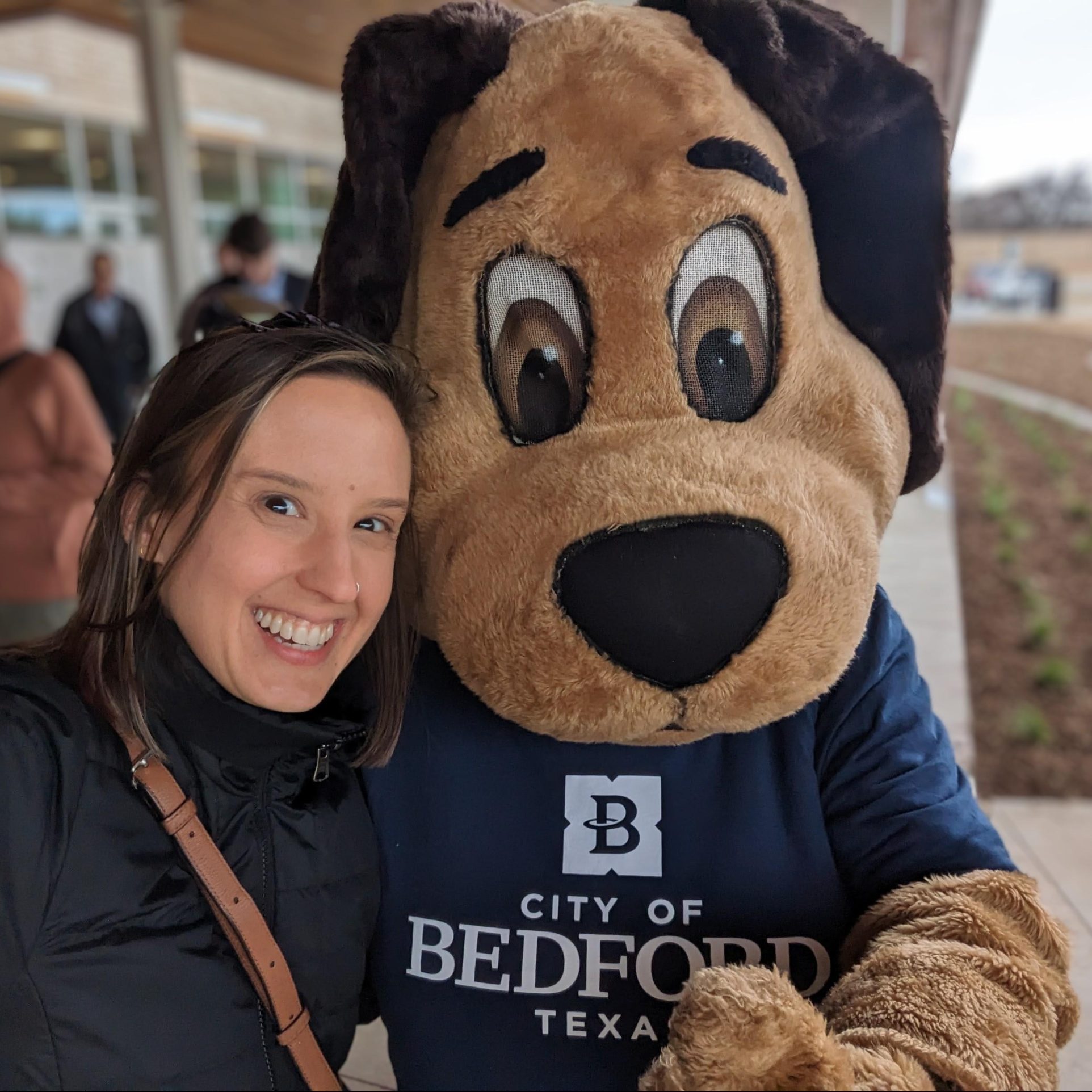 Maggie Allen and a dog mascot at a City of Bedford, TX Parks Board ribbon cutting.