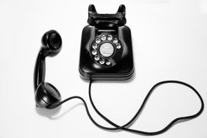 Black rotary dial phone on white surface photo by @quinoal on Unsplash