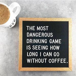 Photograph of coffee cup with sign next to it reading "The most dangerous drinking game is seeing how long i can go without coffee"