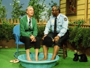 Fred Rogers and Francois Clemmens sit together with their feet in a kiddie pool.