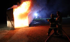 blazing fire being put out by fire fighter