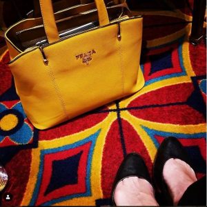 Yellow knock-off Prada purse on colorful carpet