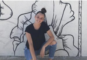 Teen girl in front of mural