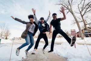 Three Young Adults Jumping in sync on Snow Plowed Sidewalk