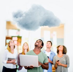 Young coworkers with laptops looking up at a cloud