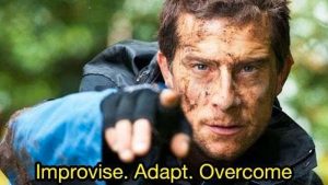 Bear Grylls stares intently into the camera and says 'Improvise. Adapt. Overcome.'