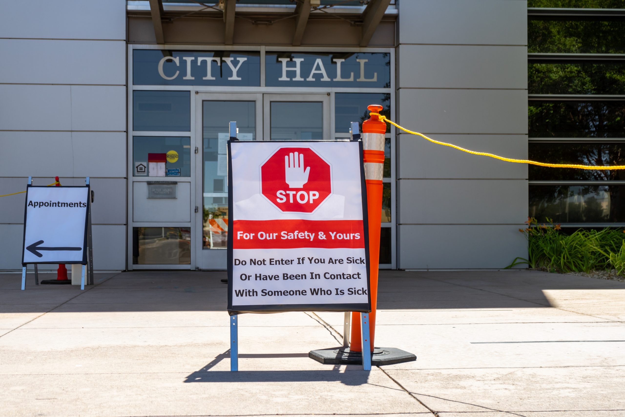 Victorville, CA, City Hall entrance with a sign describing COVID-19 precautions