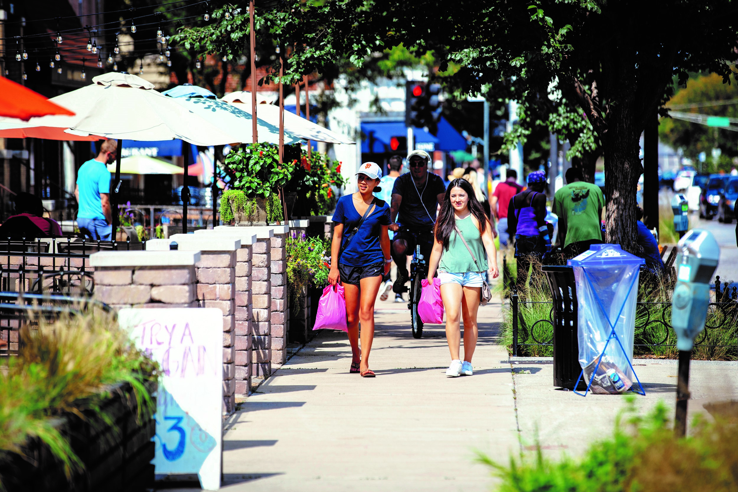 Two people walking down a busy main street