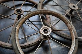 image is of three antique brown spoked wheels