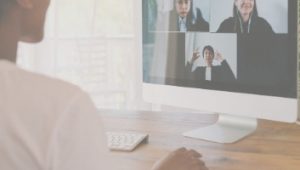 Woman on computer chatting with three people.