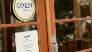 Open sign on a brown door