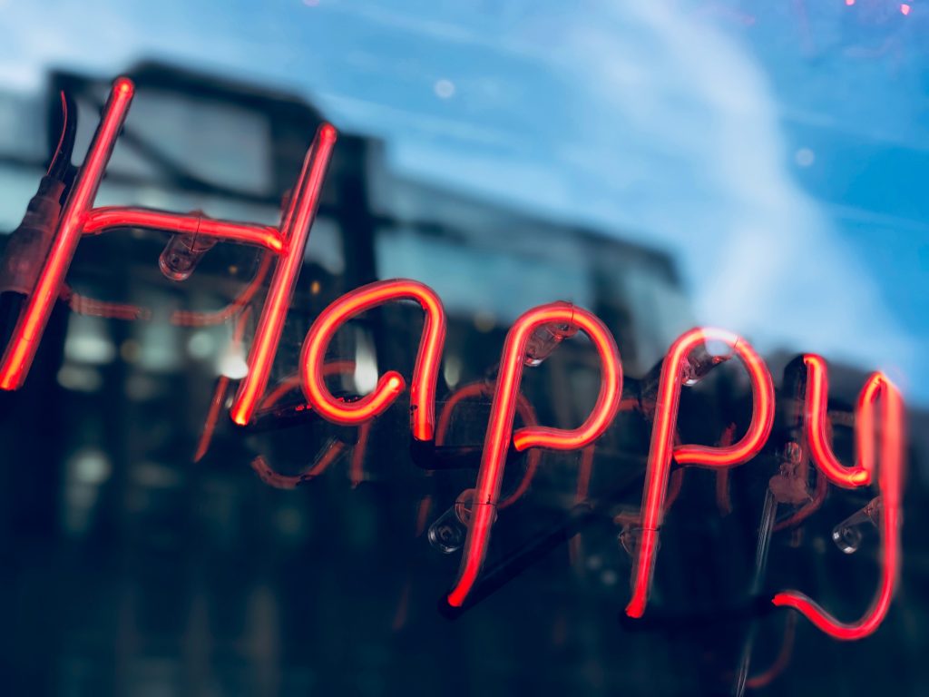  A neon sign that says Happy