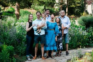 Image of a family of seven posing in a garden