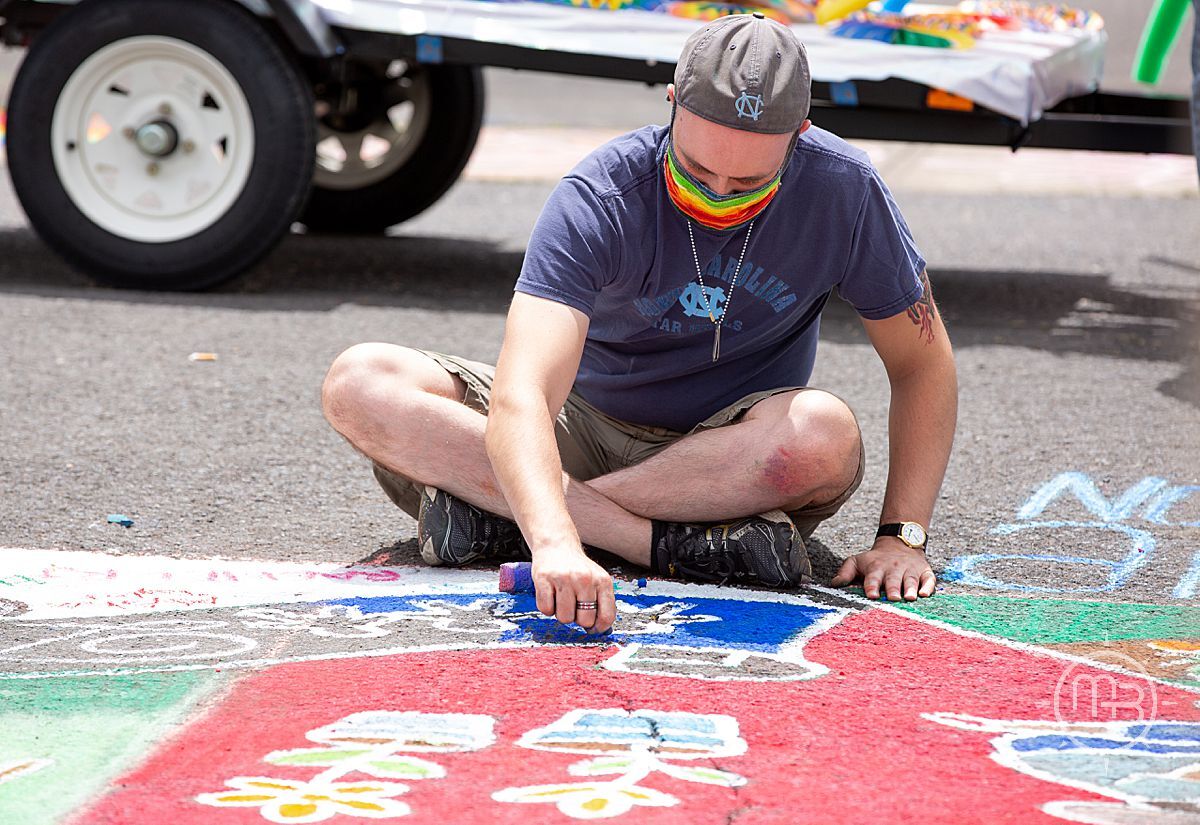 Person sitting making sidewalk art