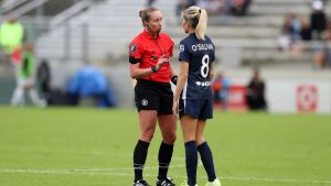 soccer referee talks to player