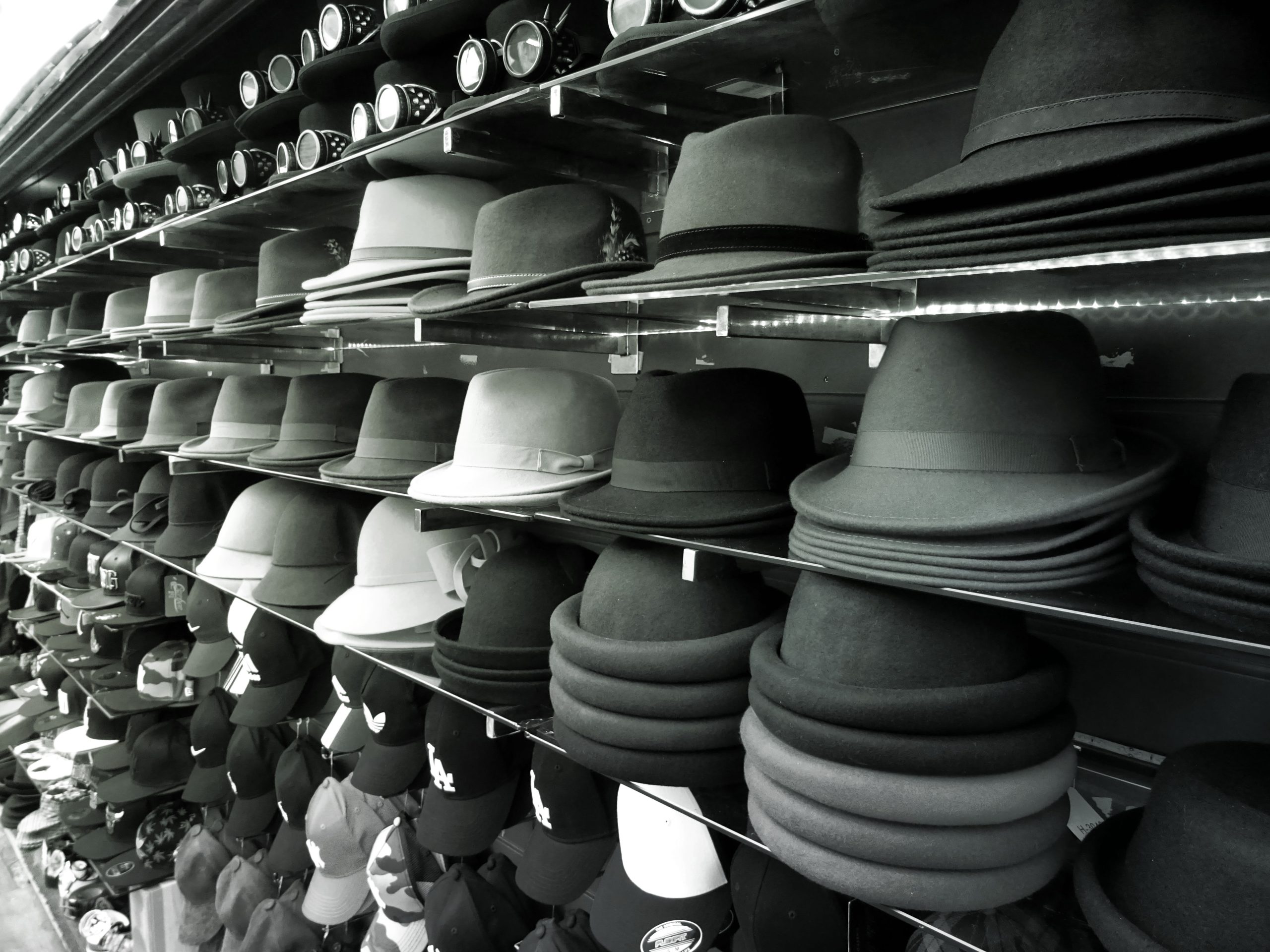 many black and white hats on a shelf