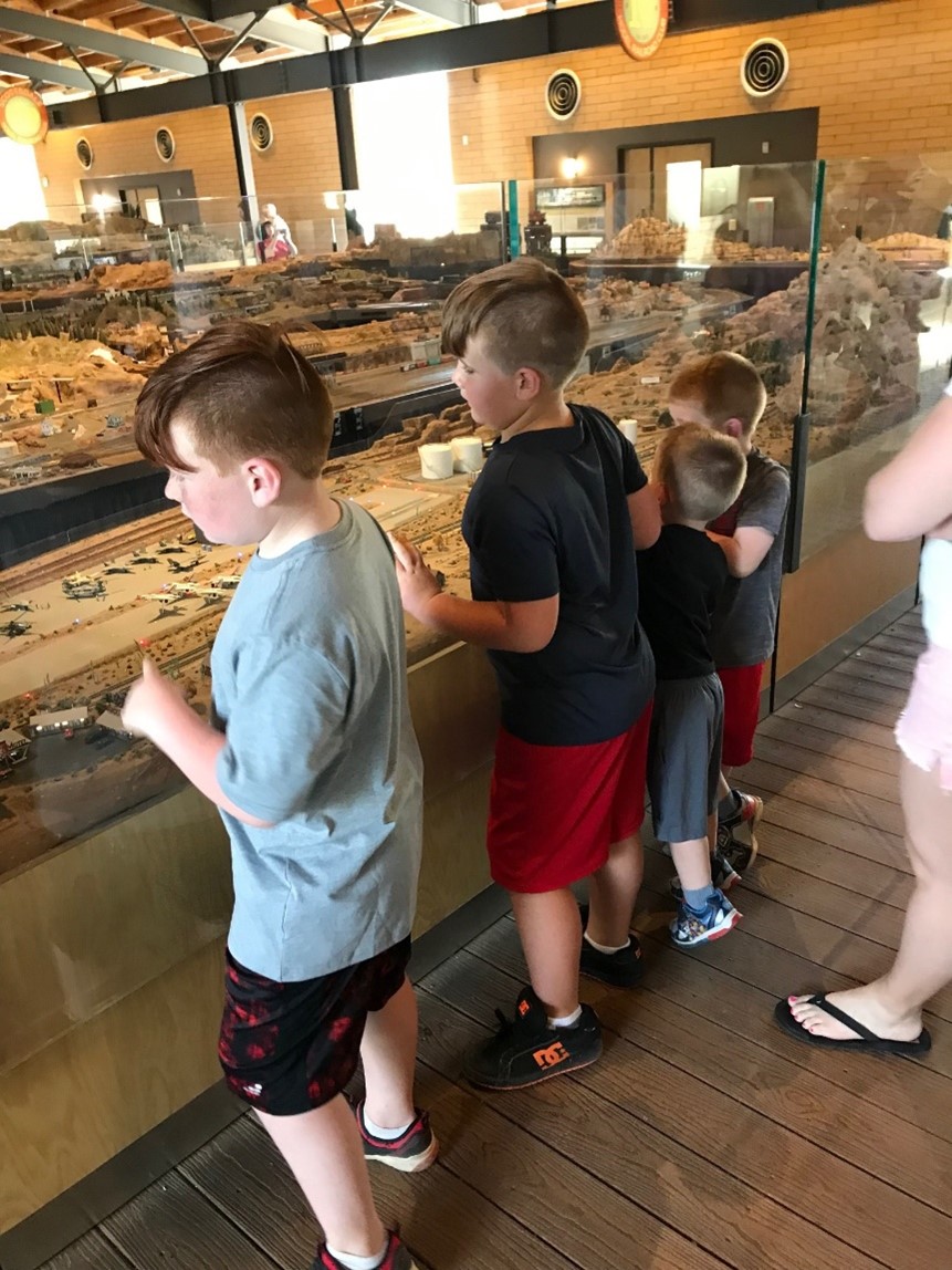 A group of boys excitedly looking at model trains