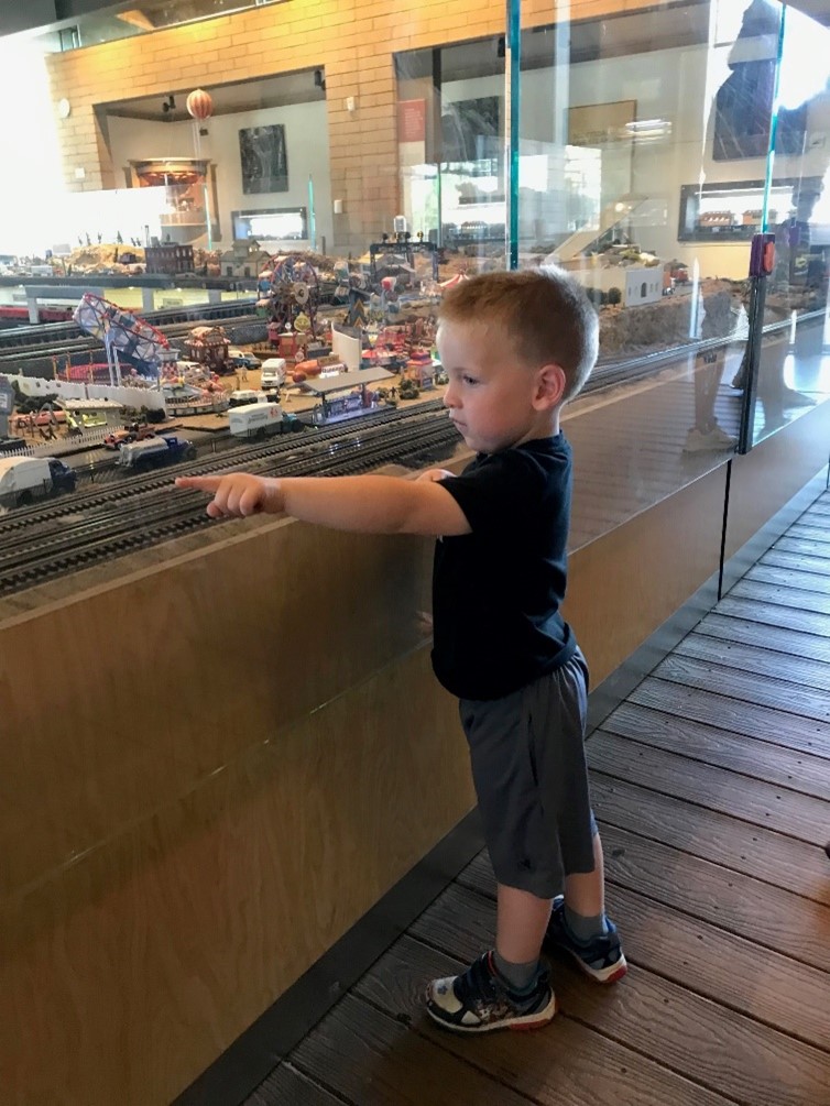 A boy pointing at model trains