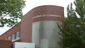 View of the side of a brick building labeled Chamber of Commerce