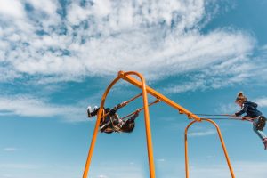 Two children on a swingset.