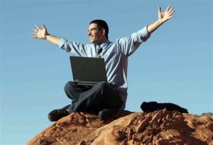 Man with a laptop on mountain top