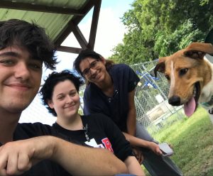 Smiling people and dog looking at camera