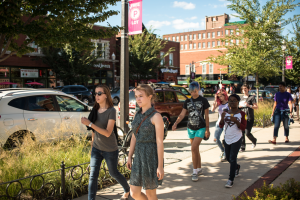 people walking on a sidewalk along a city street