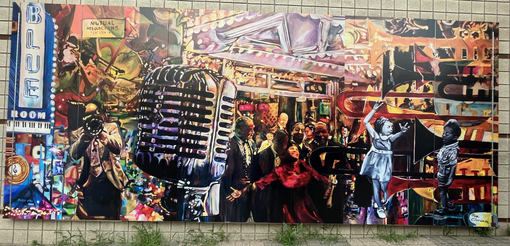 Collage mural of a music scene, with trumpets on the right, a large microphone center-left, and a Blue Room marquee on the left, with people dancing in the middle.