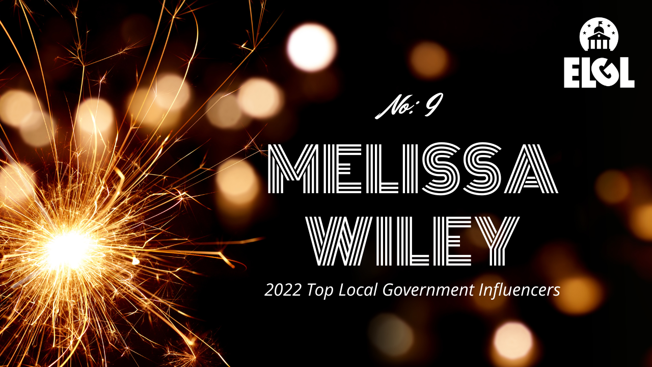 Gold firework sparkler and gold reflection spots on black background. White ELGL logo in upper right. Additional white text says "No. 9 Melissa Wiley 2022 Top Local Government Influencers."