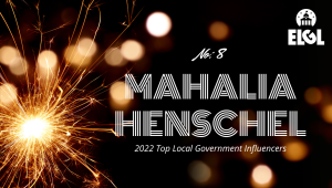 Gold firework sparkler and gold reflection spots on black background. White ELGL logo in upper right. Additional white text says "No. 8 Mahalia Henschel 2022 Top Local Government Influencers."