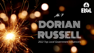 Gold firework sparkler and gold reflection spots on black background. White ELGL logo in upper right. Additional white text says "No. 7 Dorian Russell 2022 Top Local Government Influencers."