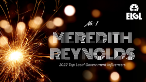 Gold firework sparkler and gold reflection spots on black background. White ELGL logo in upper right. Additional white text says "No. 1 Meredith Reynolds 2022 Top Local Government Influencers."