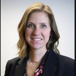 Headshot of white woman with light brown hair just past her shoulders, wearing a blouse and a dark blazer.